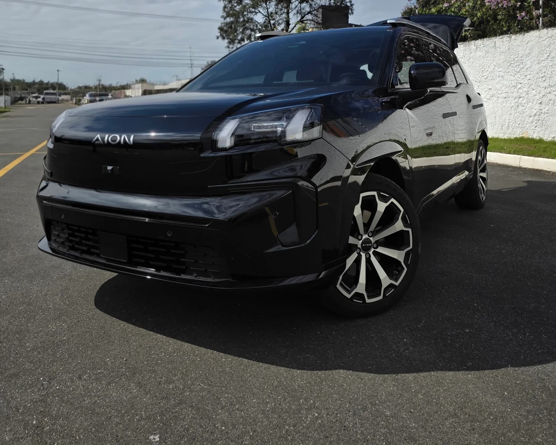 SUV executivo preto da Astaz, visto de frente em três quartos, estacionado em dia de sol